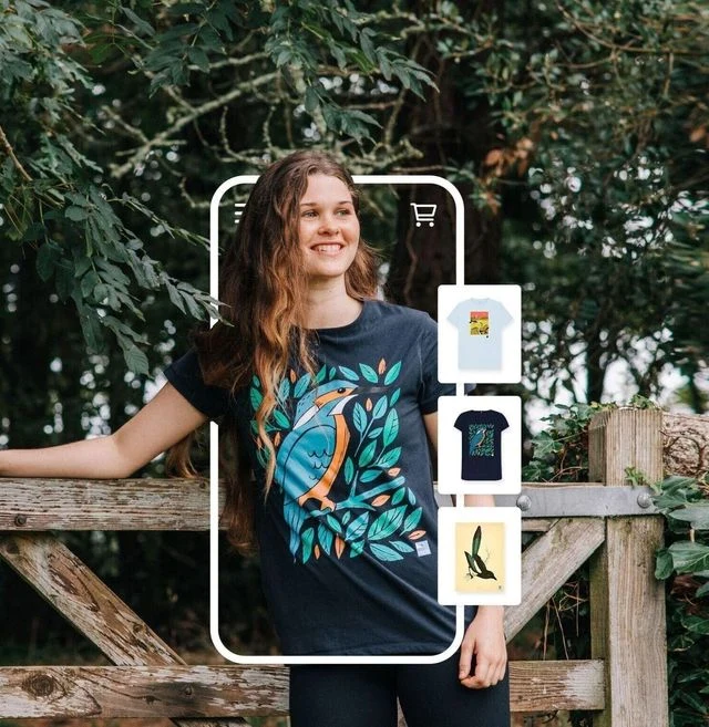 Model by a fence wearing a Charity campaign t-shirt featuring a kingfisher that was printed on demand by Triplacement. 